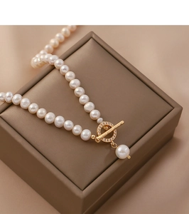 Detail of freshwater pearl necklace with gold OT clasp and teardrop pearl pendant
