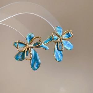 Dettaglio di orecchini a fiore in smalto blu stile francese vintage placcati in oro