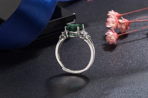 Close-up of S925 sterling silver ring with emerald green zircon and side diamonds