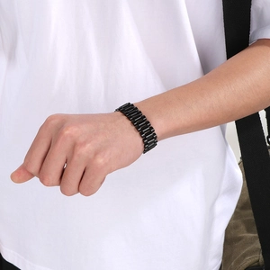 Detail of black stainless steel president link bracelet on male wrist with matte finish