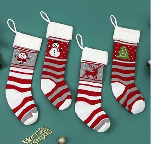 Detail view of four knitted Christmas stockings with Santa, snowman, and reindeer patterns
