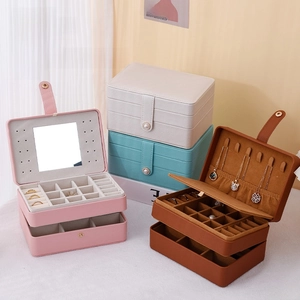 Detail of multi-layer jewelry box interior with mirror, ring slots and necklace hooks