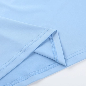 Gros plan sur le tissu tricoté bleu clair montrant l'ourlet à volants et les coutures