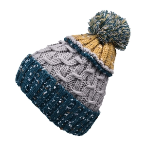Détail de la maille torsadée et du pompon bicolore sur un bonnet d'hiver chaud