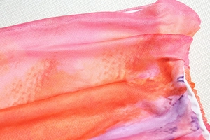 Gros plan détaillé sur le tissu en maille dégradé rose et violet de la robe courte
