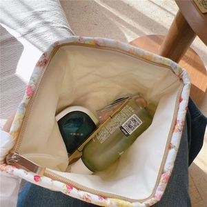 Vista dall'alto della trousse floreale aperta con interno spazioso e morbido tessuto