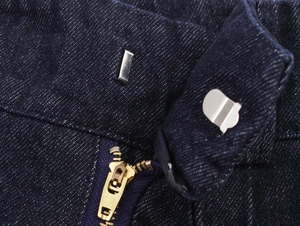 Detailansicht einer dunkelblauen Jeans mit goldenem Metallreißverschluss und stabilem Taillenhaken