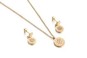 Macro view of gold geometric pendant necklace and stud earrings with roman numerals
