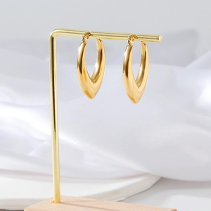 Macro view of gold-plated stainless steel geometric earrings on a display stand