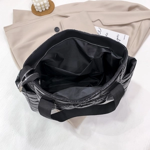 Large black quilted puffer tote bag for women showing spacious interior with zip closure
