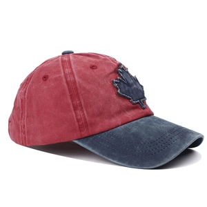 Detail of vintage washed cotton baseball cap featuring maple leaf patch and red-blue contrast