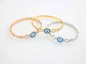 Macro detail of evil eye infinity bracelets in gold, silver, and rose gold finishes