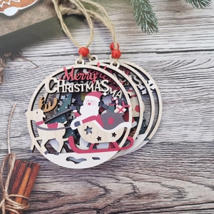 Close-up of three layered wooden Christmas ornaments with Santa sleigh and reindeer carvings