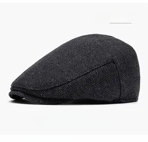 Detail view of the thick dark grey herringbone tweed texture on this men's newsboy cap