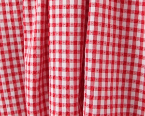 Macro view of the red and white plaid seersucker fabric with detailed waffle texture