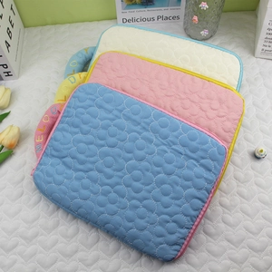 Detailed view of quilted flower laptop sleeves in pastel blue, pink and beige cotton