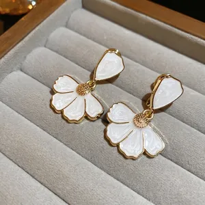 Boucles d'oreilles vintage en émail blanc avec bordure dorée sur velours gris