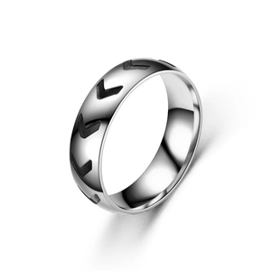 Vue macro d'une bague en acier inoxydable minimaliste avec motif fléché noir gravé