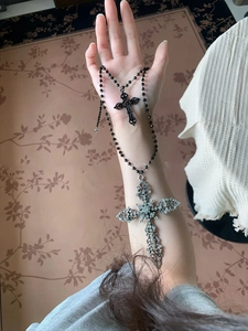 Gothic dual cross pendant with black beads and sparkling crystals on a layered necklace