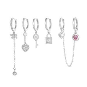 Detail of silver earrings set featuring zircon butterfly, heart, and key pendants