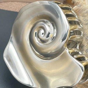 Artistic silver conch shell hair claw clip with a polished vintage geometric design