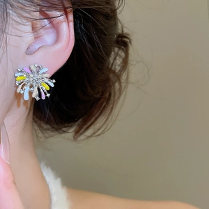 Close-up of a model wearing colorful floral stud earrings with sparkling diamonds
