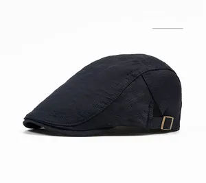 Detail of dark blue newsboy cap featuring breathable hexagonal mesh and metal buckle