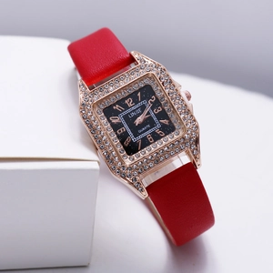 Detail of square rose gold watch with sparkling rhinestones and a bright red leather strap