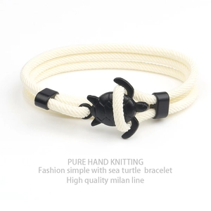 Detailed shot of hand-knitted cream Milan cord with a black sea turtle clasp