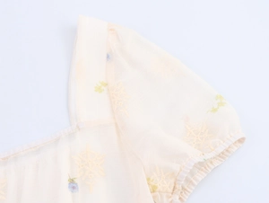 Detail von Karree-Ausschnitt und Puffärmeln mit Blumenstickerei auf dem Chiffonkleid