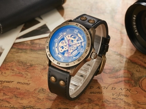 Close-up of skeleton mechanical watch with blue dial on vintage map background