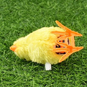 Classic wind-up plush yellow chicken toy with soft fur on realistic green grass