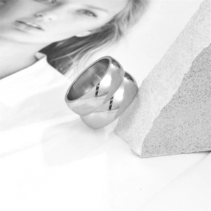 Polished silver stainless steel double-layered ring on a textured stone display