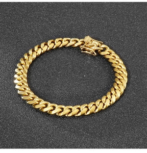 Detailed view of an 8mm golden Cuban chain bracelet on a matte black surface
