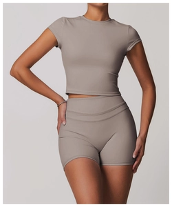 Detail of taupe short sleeve yoga crop top and high waist leggings on fit model