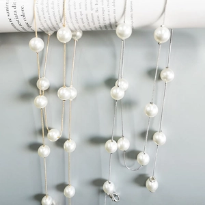 Detail of elegant pearl waist chain with gold and silver metal links and lobster clasp