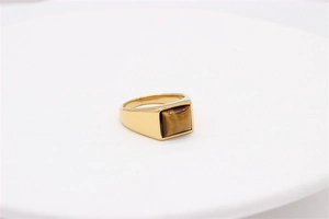 Detailed top view of gold signet ring with square tiger eye stone on white tray