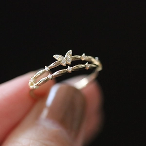 Detailed macro view of a double-layered gold butterfly ring with inlaid zircon stones