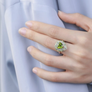 Exquisite heart-shaped green peridot ring with a double diamond halo on a silver band