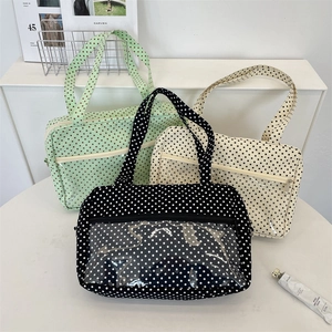 Detail of canvas tote bags in black, mint green, and beige with transparent front pocket