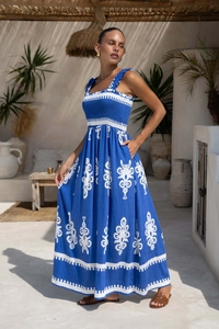 Detailed close-up of blue maxi dress showing floral print and ruffled shoulder straps