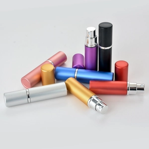 Detailed view of colorful 5ml aluminum perfume spray bottles with atomizers on white background