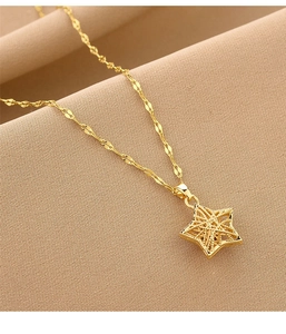 Detail of a minimalist gold hollow star pendant on a fine stainless steel chain necklace