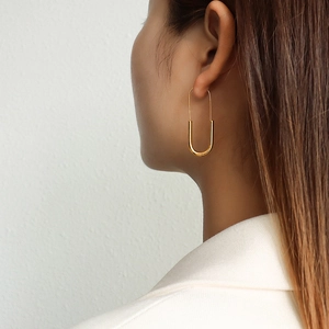 Minimalist 18K gold plated long U-shaped pin earrings shown on a model side view
