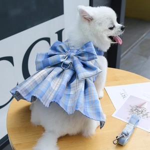 Close-up of blue plaid pet harness dress with large bow and metal D-ring for leash