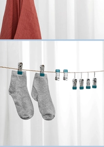 Detail of stainless steel clothes pegs with blue silicone tips holding grey socks on line