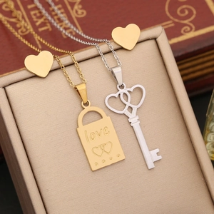 Macro shot of stainless steel love lock and key pendants with heart earrings on gift box