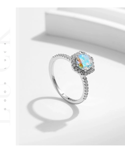 Macro detail of a silver ring with a colorful hexagon gemstone and side pavé diamonds