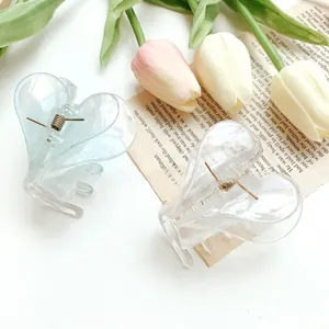Close-up of double-layer heart-shaped claw clips in clear and light blue acrylic finish