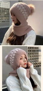 Detailed outdoor shot of a pink knitted winter hat and scarf set with fluffy pom-poms